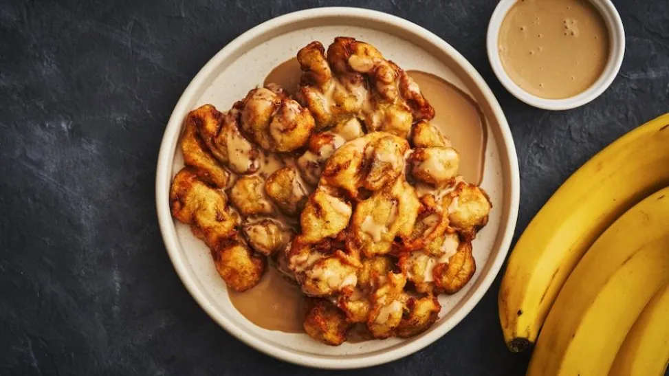 Pisang goreng karamel dengan lapisan gula yang meleleh sempurna, memberikan rasa manis dan renyah di setiap gigitan