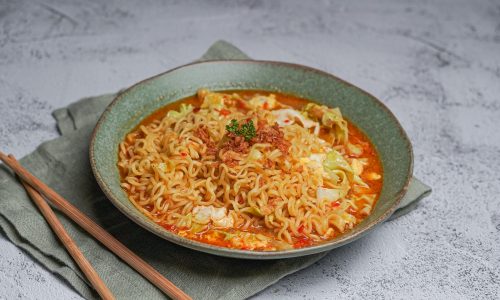 Semangkuk Mie Bangladesh dengan kuah rempah yang kental, dihiasi daun ketumbar segar dan irisan jeruk nipis